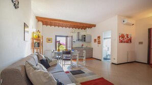 A living room with a sofa, a dining table, and a kitchen in the background. - 2 Bed-sleeps 6-aircon-town Centre-free Parking (Montagnana)