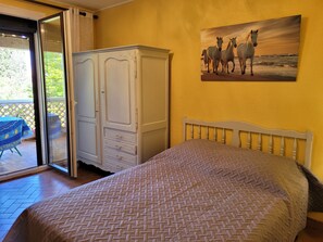Quarto com cama, guarda-roupa e pintura de cavalos na parede.