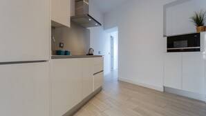 A modern kitchen with white cabinets, a stainless steel range hood, and a microwave. - SAIL Family Home by Cadiz4Rentals (Cádiz)