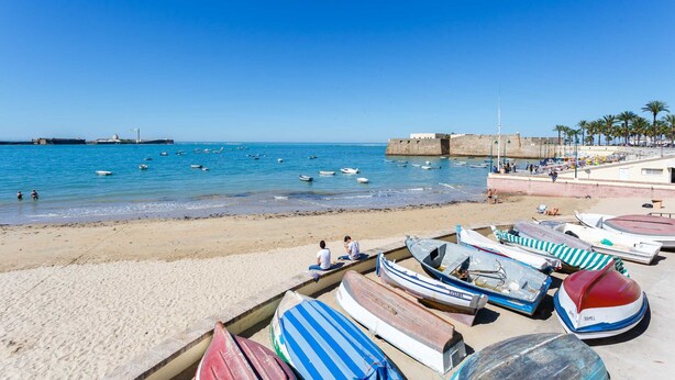 A beach with boats, a sandy shore, and a clear blue sky. - SAIL Family Home by Cadiz4Rentals (Cádiz)