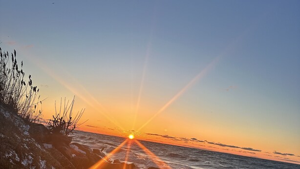 A sunset over a rocky shoreline with waves crashing against the rocks. - The Cozy Cabin near Geneva on the Lake and Wineries! (Ashtabula)
