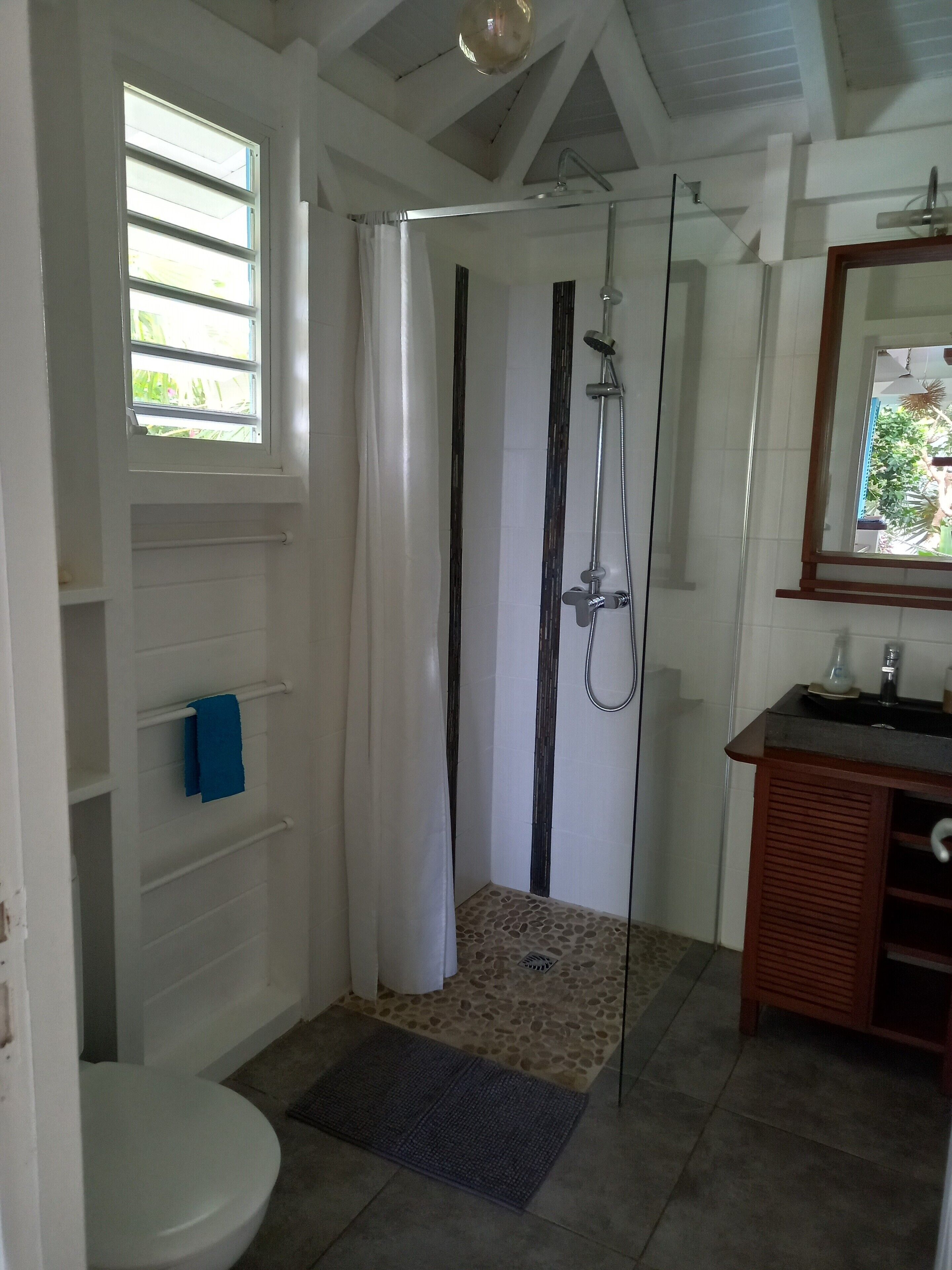 Ein Badezimmer mit Dusche, Toilette und Waschbecken.