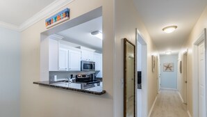 A modern kitchen with white cabinets, a granite countertop, and stainless steel appliances. - LOCATION**LOCATION**LOCATION (Gulf Shores)