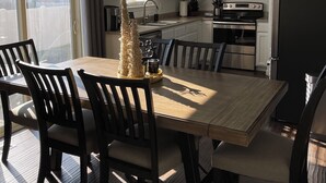A modern kitchen with white cabinets, a stainless steel stove, and a black refrigerator.