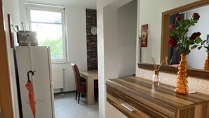 Una cocina moderna con encimera de madera, un refrigerador, una mesa de comedor con sillas y una ventana con vistas.