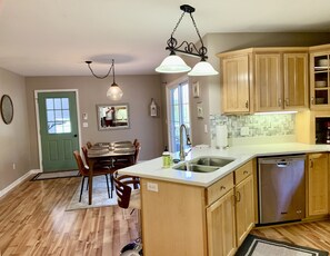 Enjoy meals in the well-lit dining area with a table and chairs.