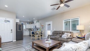 Uma sala de estar ampla com sofá, mesa de centro e um espaço de jantar com cadeiras e mesa.