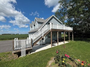 A two-story house with a covered porch and a staircase leading to the upper level. - Rusty’s Loft w/pond views! 70 plus positive reviews! (Fostoria)