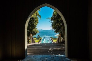 An arched doorway leading to a pool with a mountain view. - Napa Valley Vineyard View Estate (Angwin)