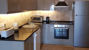 Una cocina moderna con electrodomésticos de acero inoxidable, horno empotrado y microondas.