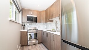 Una cocina moderna con armarios de madera, electrodomésticos de acero inoxidable y encimera de mármol.