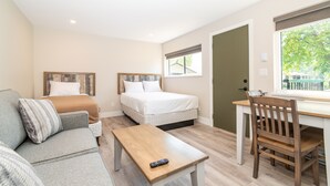 Un dormitorio con dos camas, un escritorio y una silla.