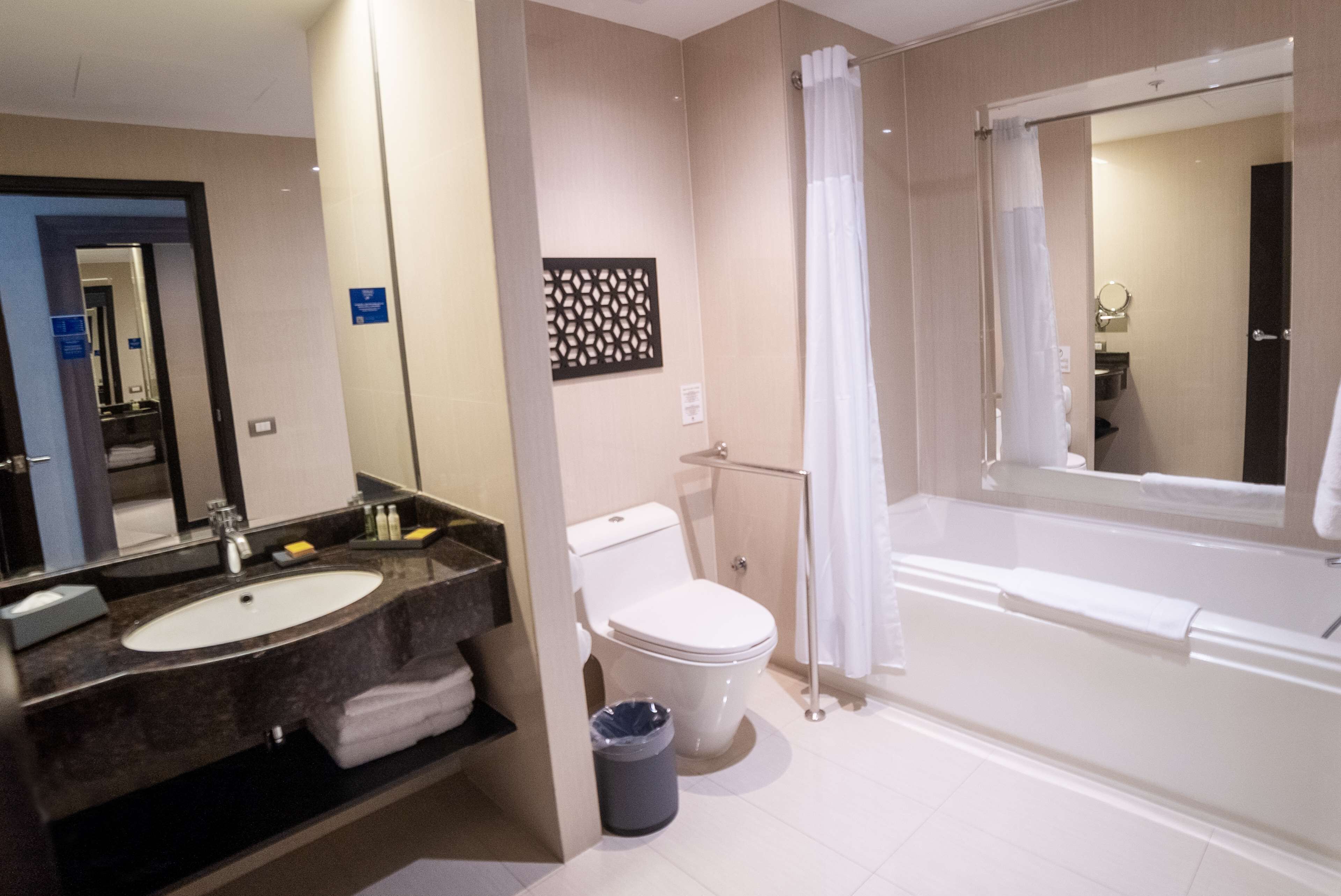 Ein modernes Badezimmer mit einem großen Waschbecken, einer Toilette und einer Badewanne.