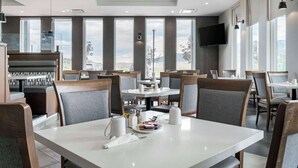 A modern restaurant with large windows, wooden furniture, and a flat-screen TV. - Best Western Premier Route 97 Vernon (Vernon)