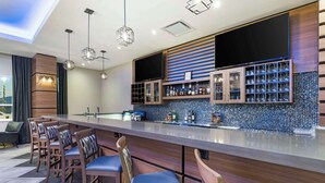 A modern bar area with a long counter, bar stools, and a television mounted above. - Best Western Premier Route 97 Vernon (Vernon)