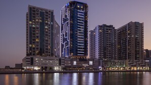 A high-rise hotel with a modern design, featuring multiple balconies and a prominent entrance.