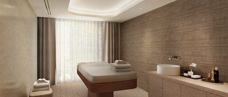 Un baño moderno con una bañera grande, un tocador de madera y una pared con textura.