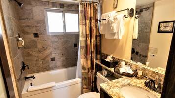 Un bagno con vasca, WC, lavandino e tenda da doccia.