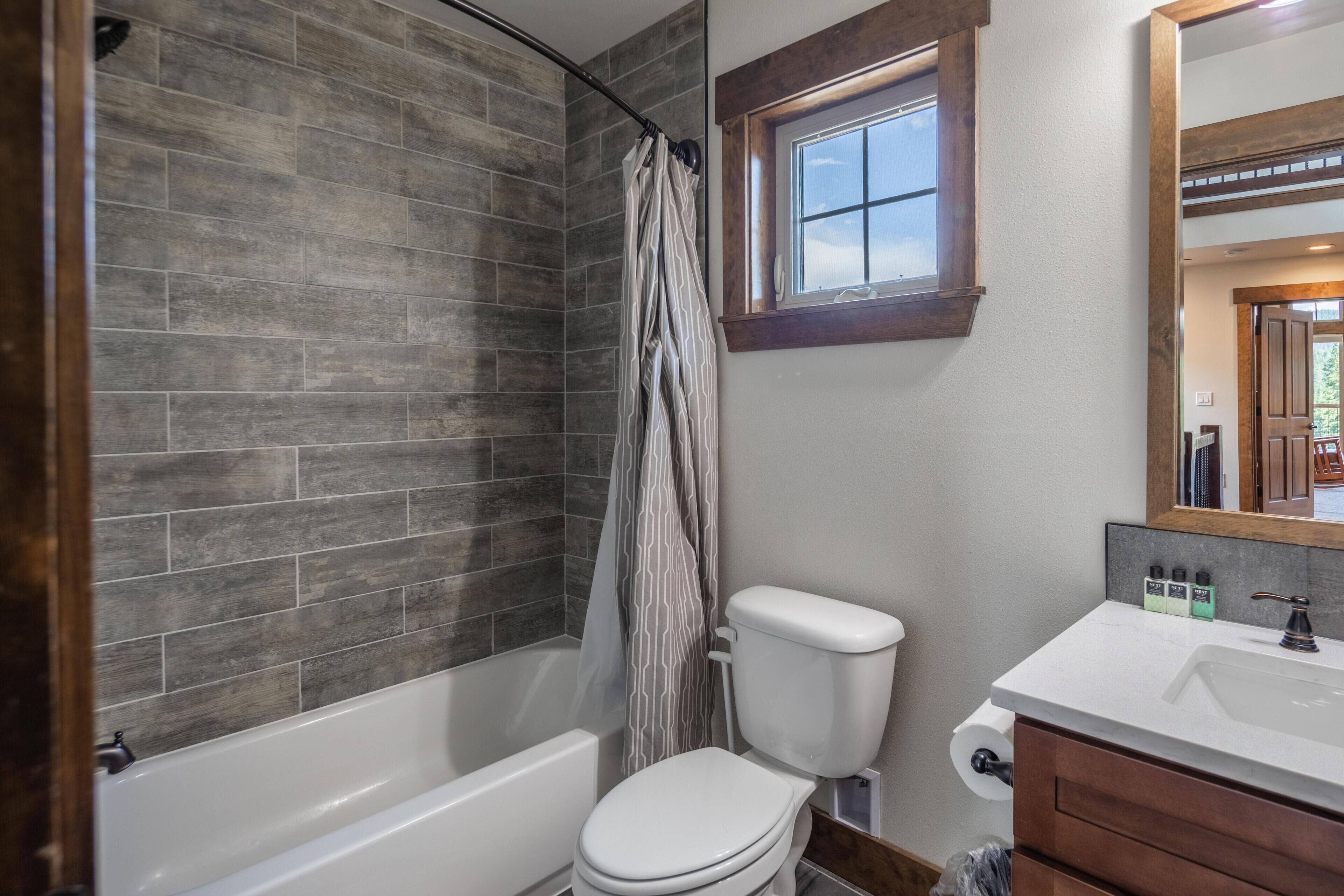 A bathroom with a bathtub, toilet, and sink.