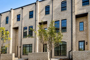 A multi-story building with a brick facade, large windows, and a flat roof.