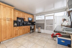 Kitchen area with microwave, coffee maker, and oven, adjacent to a window with an outdoor view.
