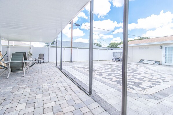 Relax in this serene outdoor patio area with a comfortable seating set and dining table.