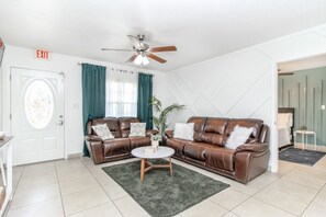 Relax in this inviting living room with a leather sofa, round coffee table, and potted plant.