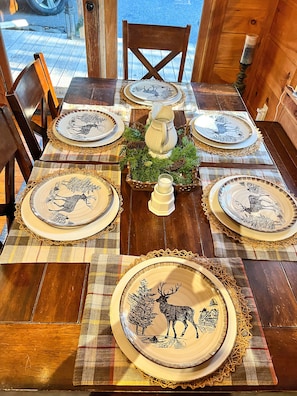 Enjoy a rustic meal at this charming table setting, complete with a decorative centerpiece and deer-themed plates.