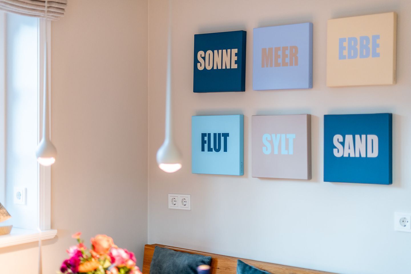 Een muur met zes gekleurde, ingelijste woorden.