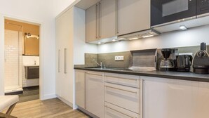 Una cocina moderna con microondas, cafetera y hervidor.