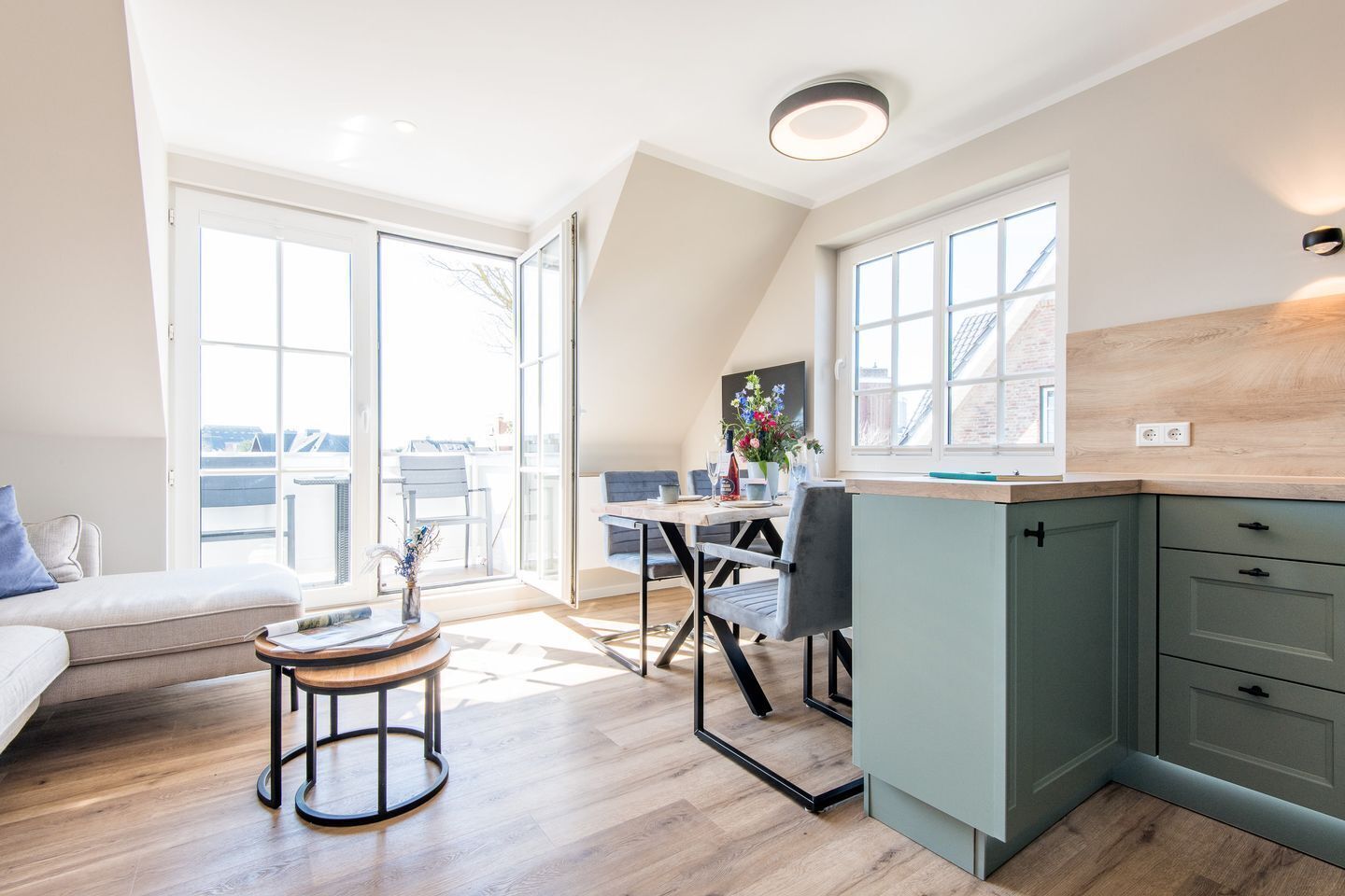 A modern kitchen with a dining area, large windows, and a view of the city.