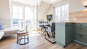 Een moderne keuken met een eethoek, grote ramen en uitzicht op de stad.