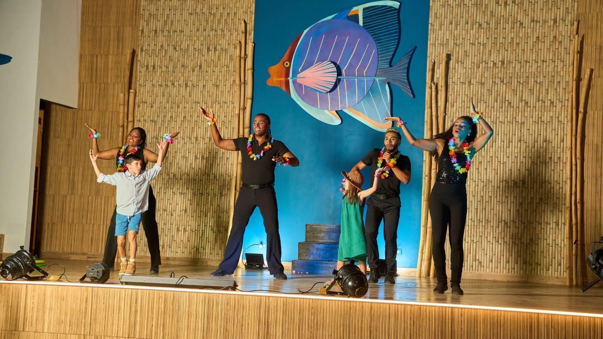 A stage with a large fish mural, wooden paneling, and a microphone stand.