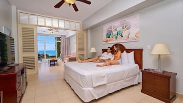 A bedroom with a bed, bedside tables, a ceiling fan, and a view through an open door.