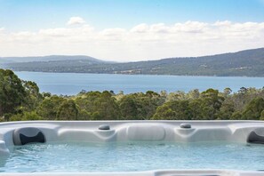 A hot tub with a view of a lake and hills. - Ocean views, spacious & private, hot hub (Lower Snug)