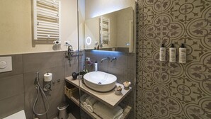 Um banheiro moderno com um espelho grande, uma pia embutida e um porta-toalhas.