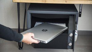 A person retrieving a laptop from a black drawer unit. - Double/twin room with bathroom and king size bed near Pescara airport (Pescara)