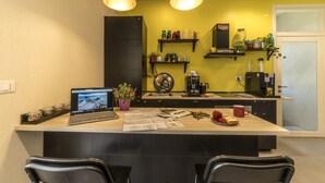 A modern kitchen with a central island, a laptop, and various kitchen items.