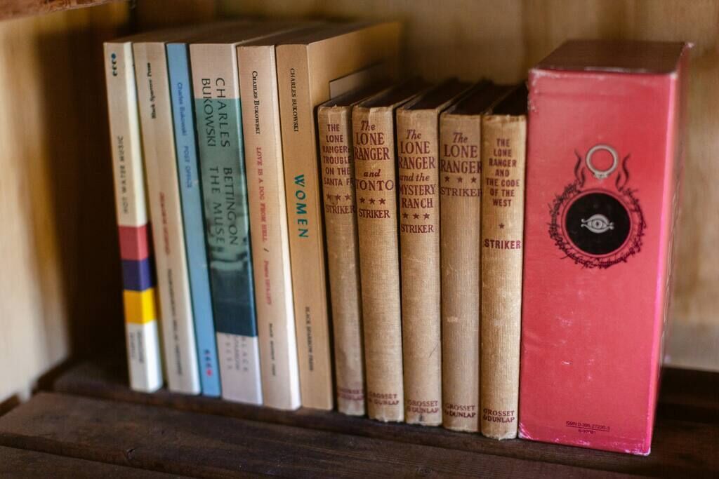 A shelf with books, including multiple copies of 'The Lone Ranger and the Mystery of the Ranch' and 'Women in Love'.