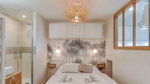 Een moderne slaapkamer met een bed, een douche en uitzicht op zee.
