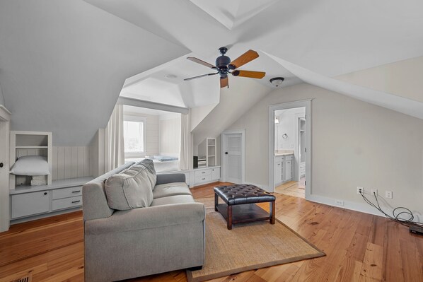 A spacious loft bedroom with a high ceiling, a ceiling fan, a large window, and a built-in wardrobe. - Big Red- Just Hook it! (Oriental)