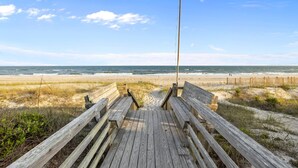 A wooden boardwalk leading to a beach with a wooden fence and a tall pole. - OCEAN VIEWS | 2nd Row | Heart of EI | NEWLY RENOVATED!! (Emerald Isle)
