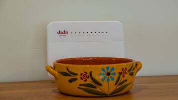 A yellow ceramic bowl with floral designs on a wooden table.