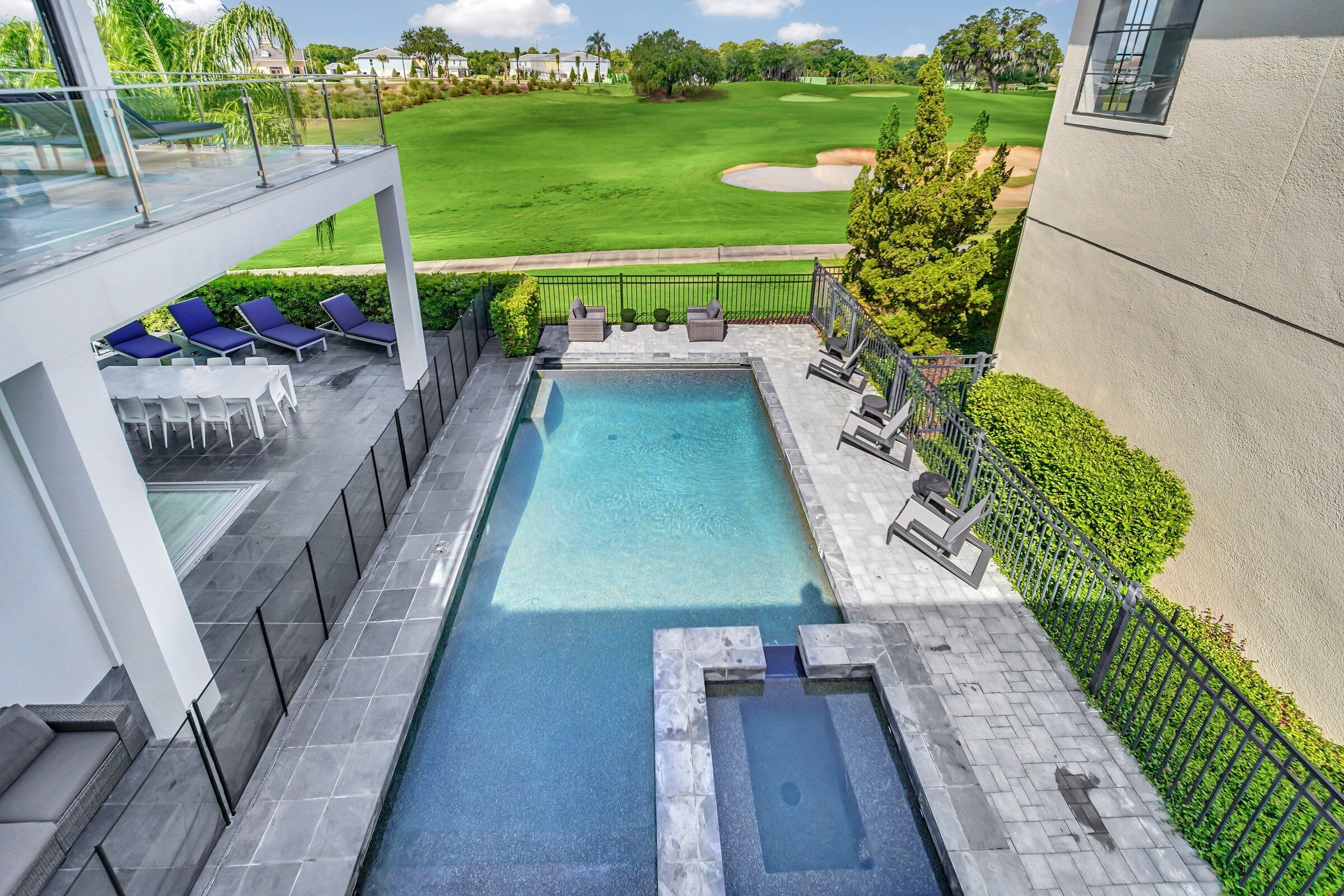 Una piscina exterior moderna con vistas a un campo de golf.