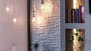 A modern interior with a stone wall, bookshelves, and a 'dream' sign. - Gregory's loft (100 meters from the beach) (Αγία Άννα, Εύβοια)
