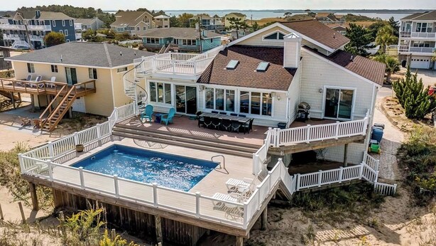 A beachfront house with a large deck, a swimming pool, and multiple levels. - Shore Elegance | Oceanfront | Private Pool (Virginia Beach)