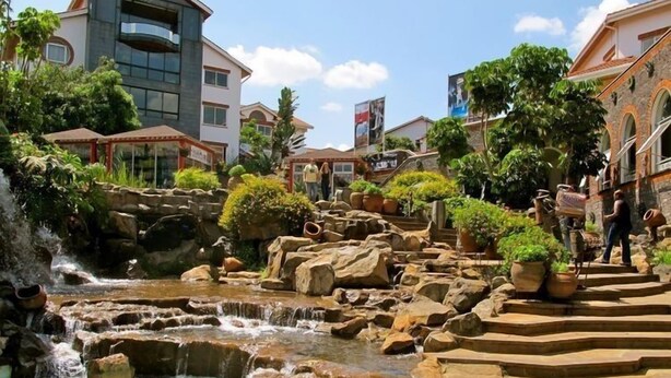 A pool area with a waterfall, surrounded by rocks and potted plants. - The Studio | Nairobi | 5* Luxury (UN & Two Rivers) (Ruaka, Nairobi)