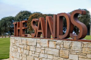 A stone wall with large, rust-colored letters spelling "THE SANDS". - The Sands Torquay (Torquay)