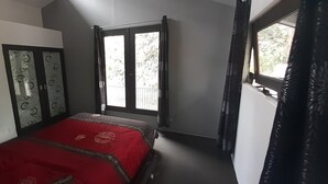 A room with a bed, a window with curtains, and a door with patterned glass. - Luxury Designer home on Beautiful Macleay Island, just 1 hour from Brisbane! (MacLeay Island)