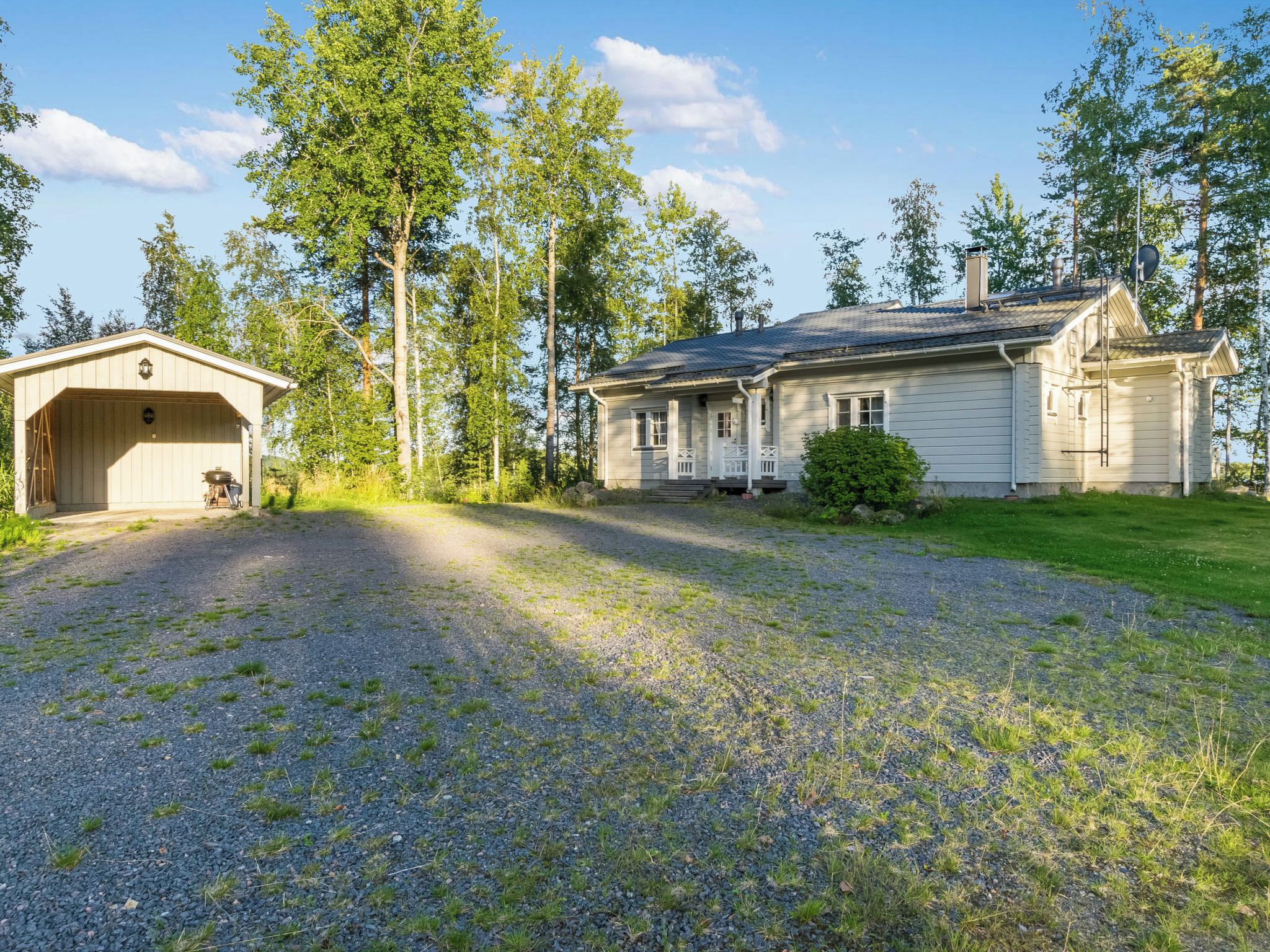 A two-story house with a covered garage and a well-maintained lawn.